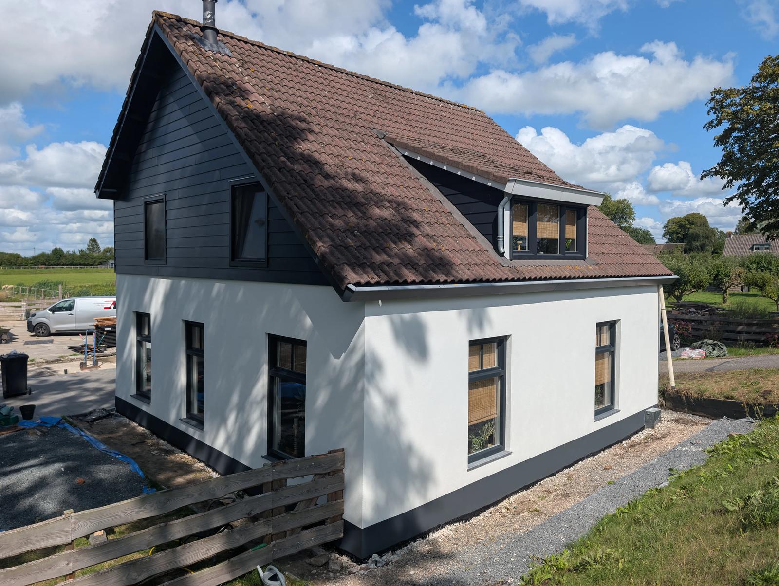 Woning met witte kalkgevel, donkere plint en antraciet kozijnen